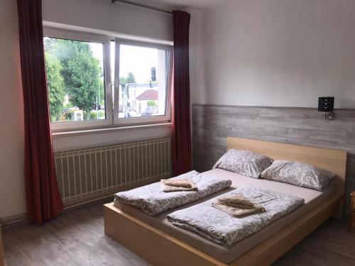 1 dormitorio con 1 cama con 2 almohadas y ventana en Makss, en Wels