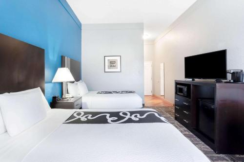 a hotel room with two beds and a flat screen tv at La Quinta by Wyndham Kerrville in Kerrville