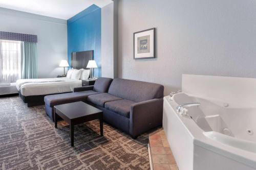 a hotel room with a couch and a bed at La Quinta by Wyndham Kerrville in Kerrville