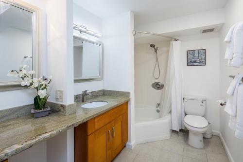 a bathroom with a sink and a toilet and a shower at Waikiki Penthouse @ The Monarch Hotel in Honolulu