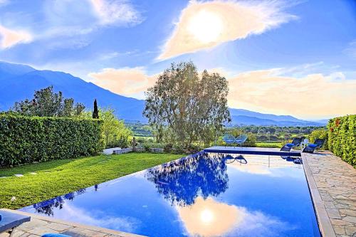ゲオルギオポリスにあるCretan Mansion with Heated Swimming Poolの山々を背景にした庭のスイミングプール