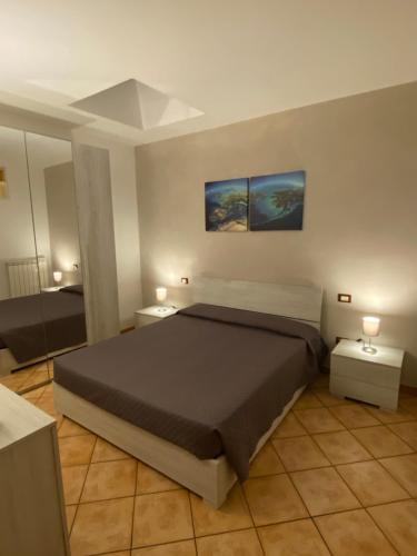 een slaapkamer met een groot bed en 2 tafels bij La casetta in Porto SantʼElpidio
