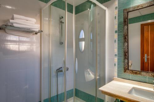 a bathroom with a shower and a sink and a mirror at Hotel Ciudad de Martos in Martos