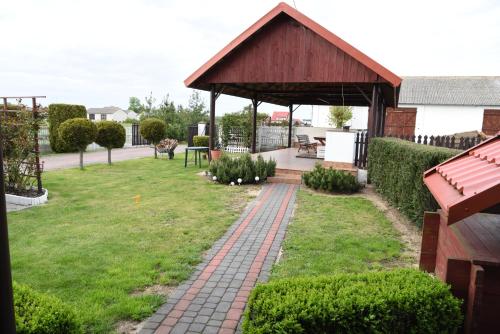a garden with a pavilion and a brick path at Agroturystyka Kobylnica nad Wisłą in Kobylnica