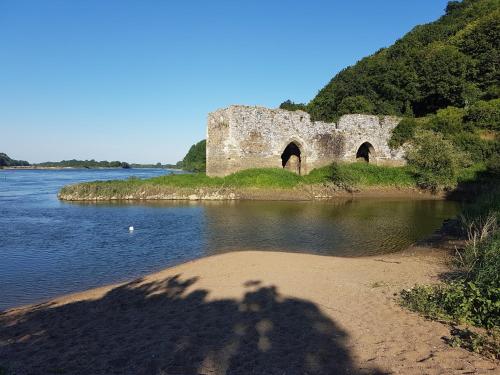 a shadow of a person taking a picture of a castle in the water at Lucriolla in Champtoceaux