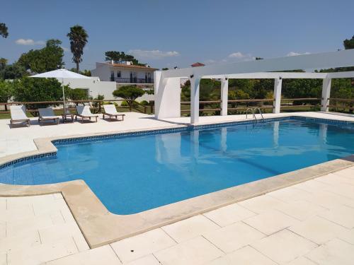 a swimming pool with a patio and a house at Vila Louro in Santa Cruz