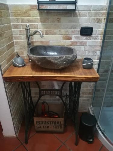 a stone sink on a wooden table in a bathroom at IL CASALE DEL MAGRA in Ameglia