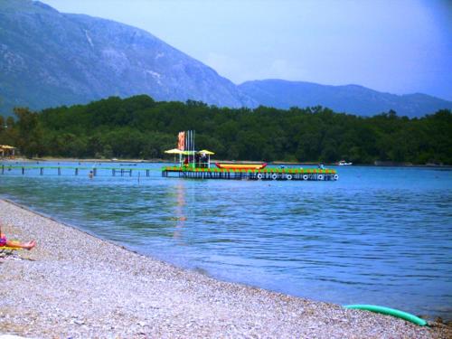 a dock on a lake with a playground on it at Andreas House in Dassia