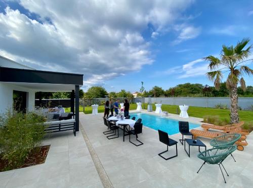 a patio with a table and chairs next to a pool at Villa Eni Medulin Sisan heated pool in Šišan