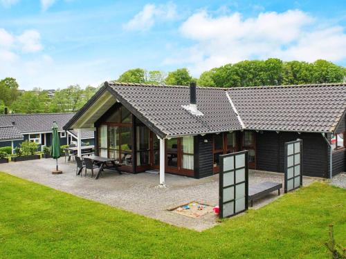Loddenhøjにある8 person holiday home in Aabenraaの小さな家(パティオ、テーブル付)