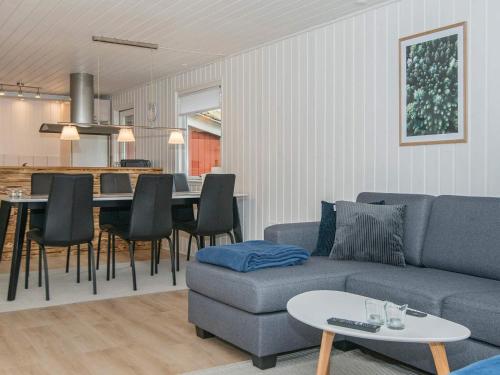 a living room with a couch and a table at 6 person holiday home in R m in Bolilmark