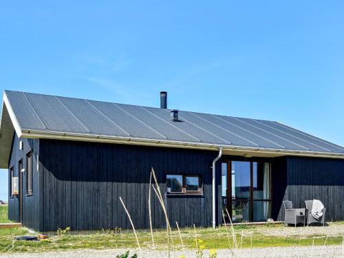 una casa negra con techo solar en 8 person holiday home in Ulfborg en Thorsminde