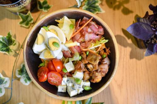 a bowl of food sitting on a wooden table at Central Inn in Zlatibor