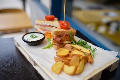 a sandwich and chips on a plate on a table at Central Inn in Zlatibor