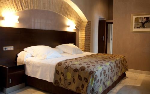 a bedroom with a large bed with a large headboard at Pintor El Greco in Toledo