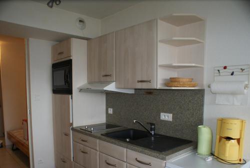 une cuisine avec un évier et un plan de travail dans l'établissement Les Charmilles, à Gérardmer