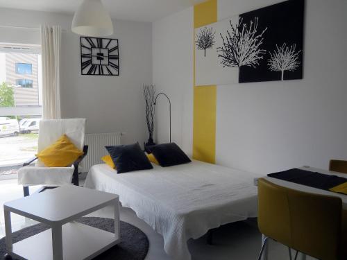 a bedroom with two beds and a table and a chair at Apartament Maxi in Poznań