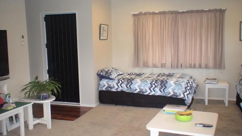 salon z łóżkiem i oknem w obiekcie The Practice Fairway w mieście Tauranga