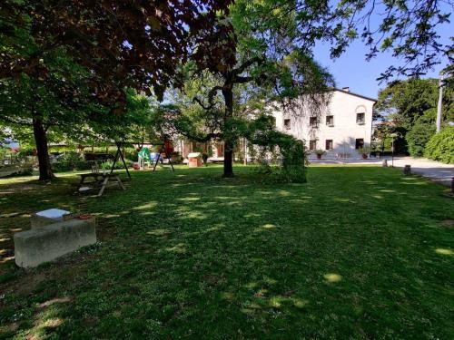 een park met bomen en een bank in het gras bij Agriturismo La Sophora in Montegaldella