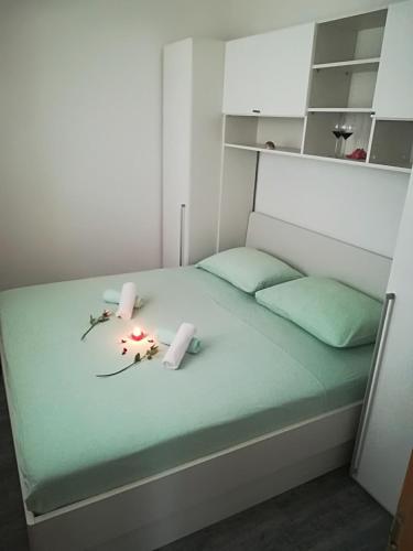 a bed with two candles and flowers on it at Apartment Nela in Baška Voda