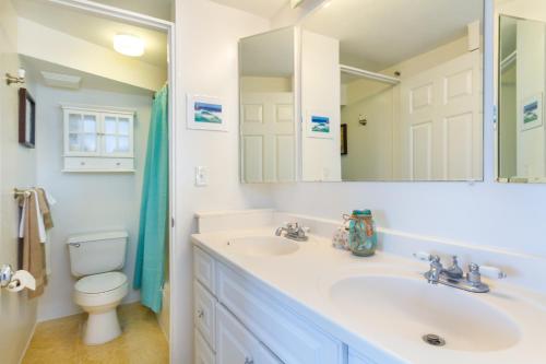 a bathroom with a sink and a toilet and a mirror at 2 Bedroom Penthouse w/Ocean Views in Honolulu