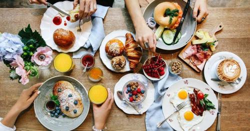 un gruppo di persone seduti intorno a un tavolo con prodotti per la colazione di Bed And Breakfast Belvedere a Suvereto