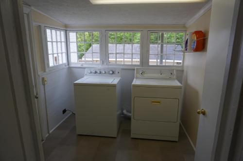 a kitchen with a stove and a sink and windows at Renovated 1928 bungalow on a former asylum campus in Milledgeville