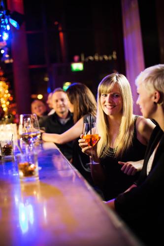 a group of people sitting at a bar at pentahotel Kassel in Kassel