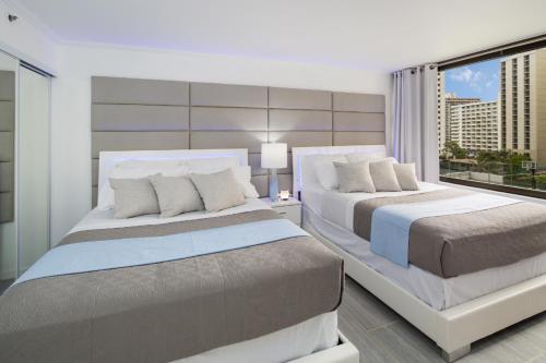 A bed or beds in a room at Waikiki Banyan Modern One Bedroom Free Parking