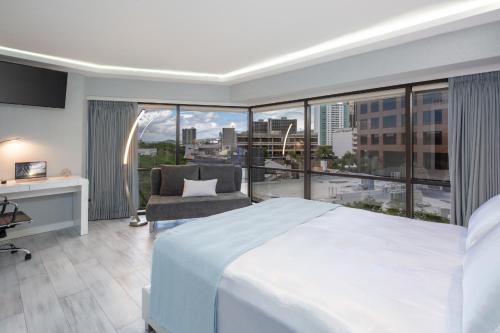 a bedroom with a white bed and a large window at Executive Hotel Suite Downtown Free Parking in Honolulu