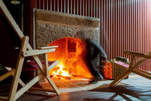 a fire pit with a person standing next to it at Encosta do Sobreiro - Serra da Estrela in Fornos de Algodres
