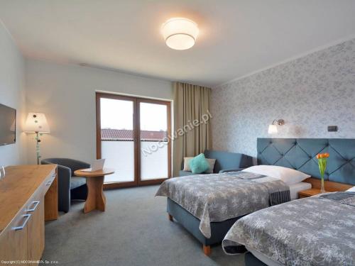 ダルウフコにあるApartamenty Ola IIのベッド2台とソファが備わるホテルルームです。
