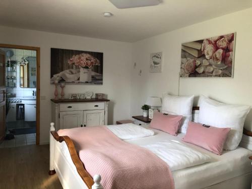 a bedroom with a bed with pink and white pillows at Lili´s Bungalow auf der Halbinsel Scheid in Waldeck