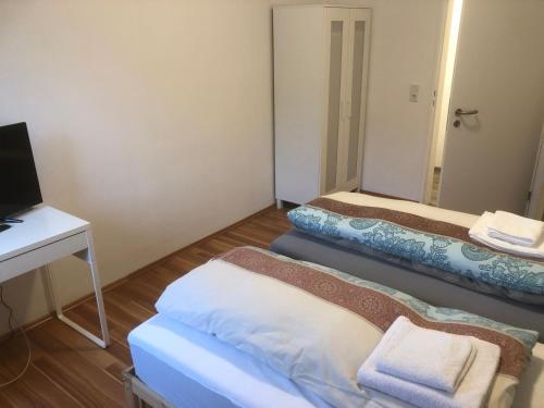 a small room with three beds and a desk at Bosskopp in Alzenau in Unterfranken