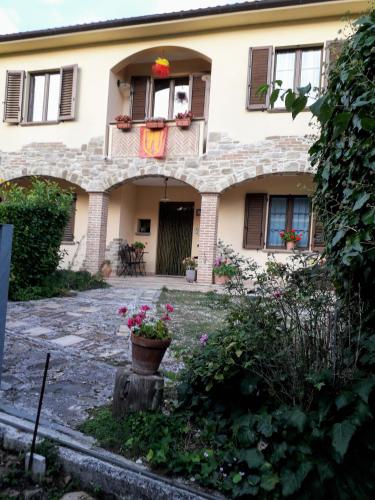 an old house with flowers in the yard at Il Castellare in Gualdo Tadino