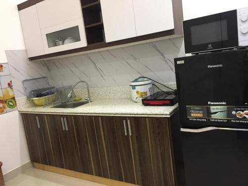 a kitchen counter with a sink and a microwave at Khu phố Water Front in Hai Phong