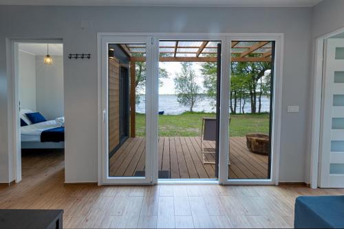 Habitación con puerta corredera de cristal que da a un patio. en Mazurski Widok, en Wydminy