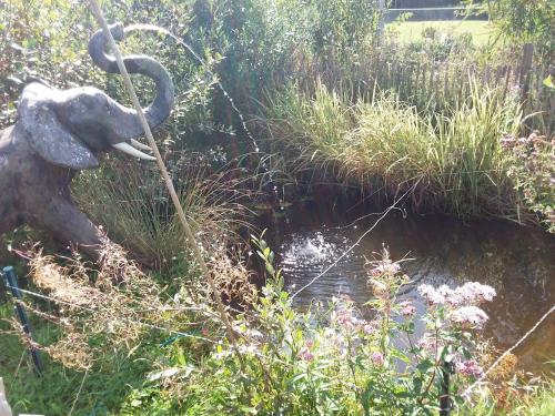 a garden with an elephant statue in the grass at Roulotte de luxe vue mer 180° ,et un ha de verdure in Plougastel-Daoulas