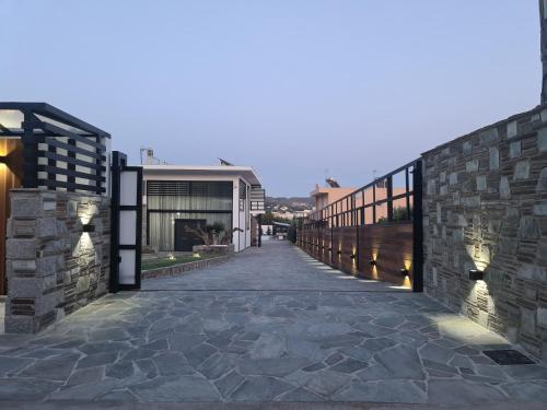 une passerelle menant à un bâtiment avec un mur en pierre dans l'établissement Olivujoj Villajoj - Deluxe Villa with Detached Pool House, à Anavyssos