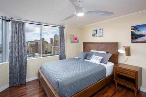 um quarto com uma cama e uma grande janela em 2 Bedroom Corner Suite & Tropical Views em Honolulu