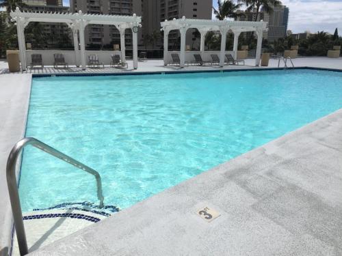 a large swimming pool with blue water in a building at 2 Bedroom Corner Suite & Tropical Views in Honolulu