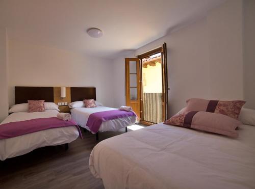 a room with two beds and a window with a mirror at Apartamentos Barrio Húmedo Catedral 2 in León