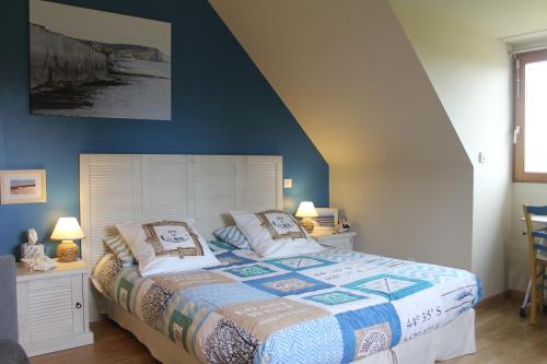 Schlafzimmer mit einem Bett mit blauer Wand in der Unterkunft Chambre D'hotes Le Clos Fleuri in Criel-sur-Mer
