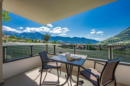 a table and chairs on a balcony with a view at Das Mitterplarser Hotel in Lagundo