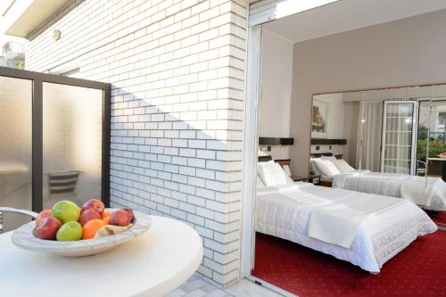 a bedroom with a bed and a bowl of fruit on a table at Victory Inn in Athens