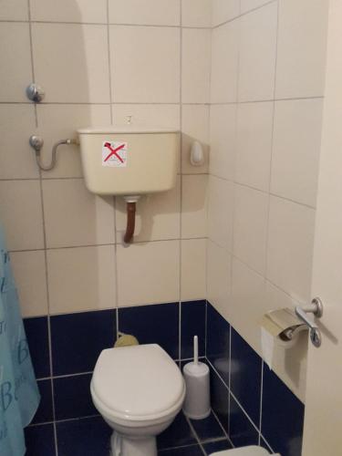 a bathroom with a toilet with a red x on it at faliraki apartments in Benitses