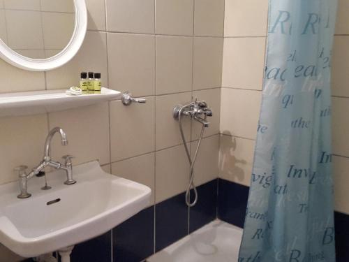 a bathroom with a sink and a shower curtain at faliraki apartments in Benitses