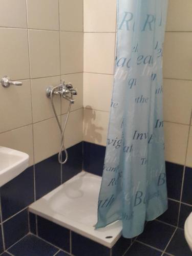 a bathroom with a shower curtain with writing on it at faliraki apartments in Benitses