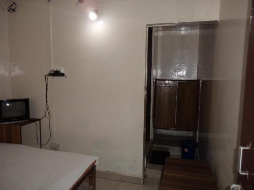 een kleine kamer met een raam en een televisie bij Hotel Embassy in Shillong