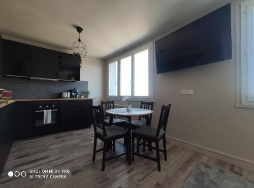 a kitchen and dining room with a table and chairs at Le Majestic idéal famille, entreprise, proximité centre, fac Jean monnet in Saint-Étienne